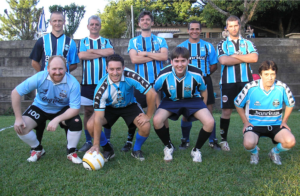 a foto mostra time de futebol usando uniforme do grêmio