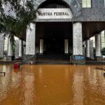 foto do prédio da justiça federal em porto alegre com a enchente na escadaria